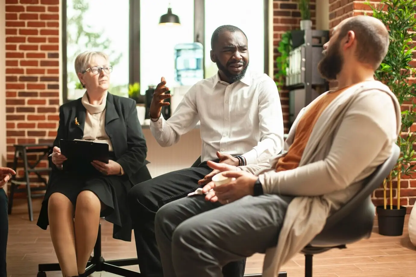 Hombre negro enojado compartiendo en un programa de rehabilitación